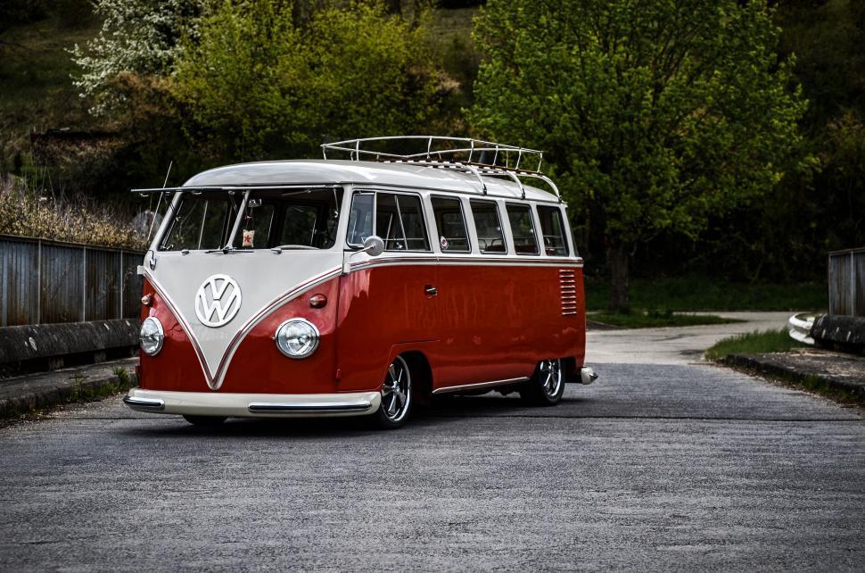 Free Image of Red and White VW Bus Driving Down a Road 