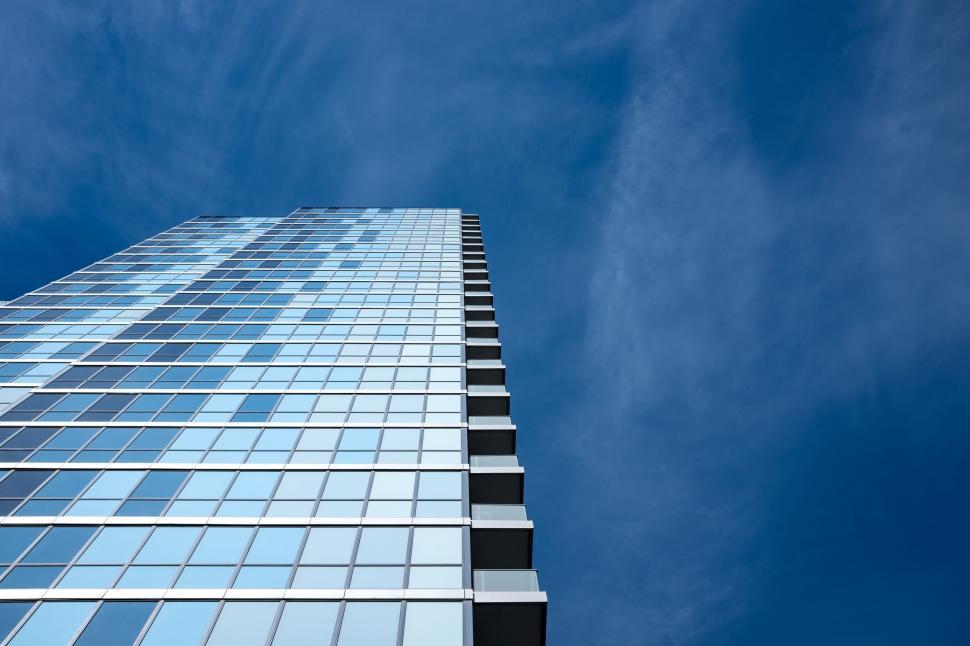 Free Image of Modern Skyscraper With Numerous Windows Against Blue Sky 