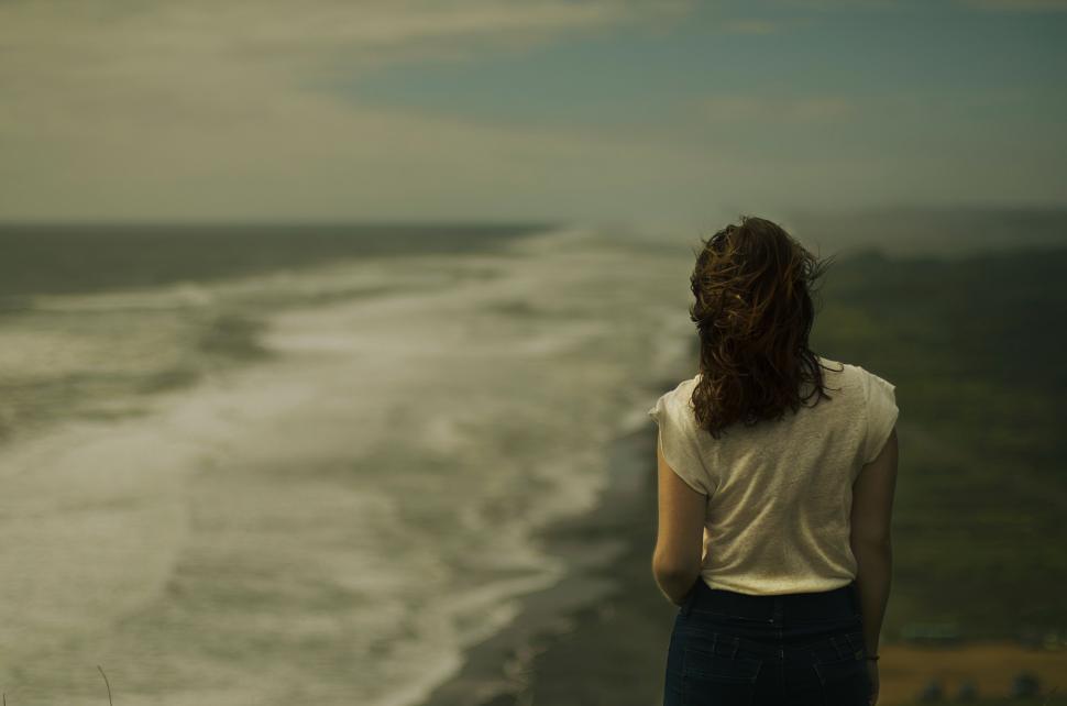 Free Image of Woman Standing on Cliff Overlooking Ocean 