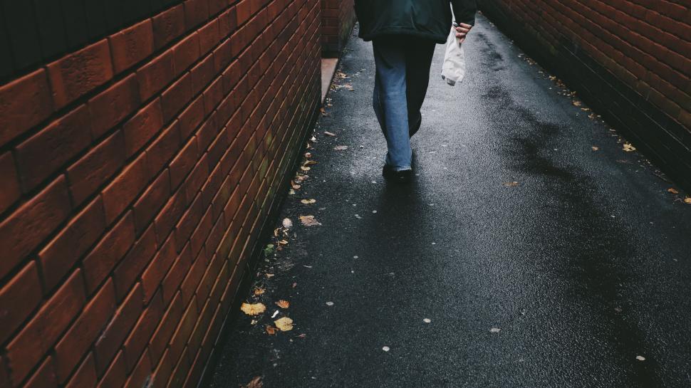 Free Image of Person Walking Down a Dark Alleyway 