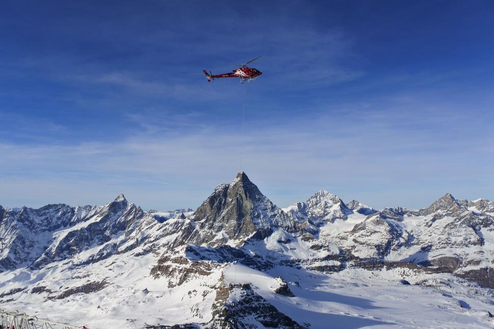 Free Image of Helicopter Flying Over Snow Covered Mountain Range 