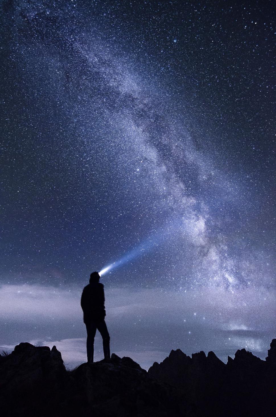 Free Image of Man Standing on Mountain Summit Under Starry Night Sky 