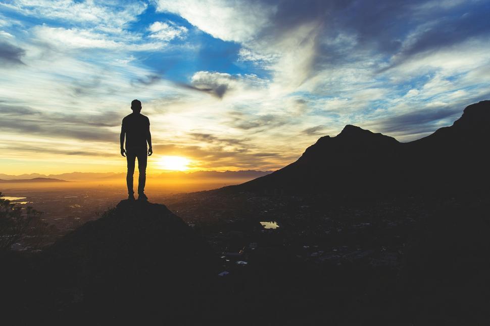 Free Image of Man Standing on Mountain Top at Sunset 