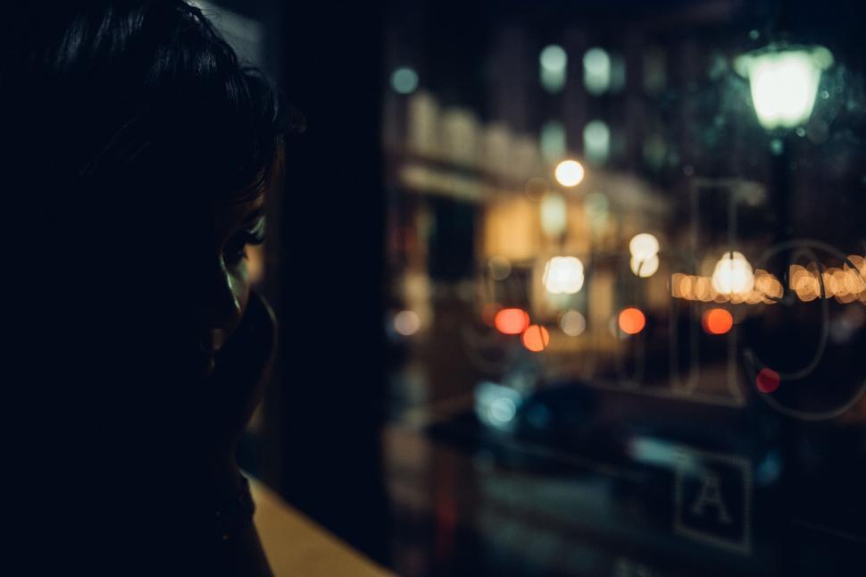 Free Image of Person Standing by Window at Night 