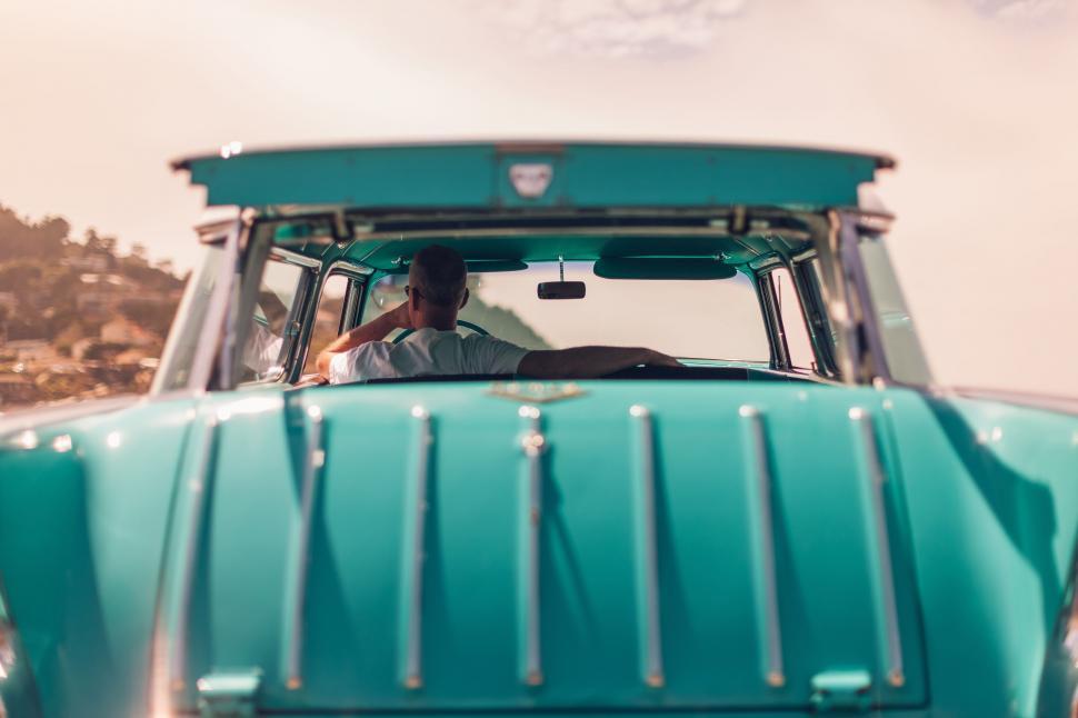 Free Image of Man Sitting in the Drivers Seat of a Green Truck 
