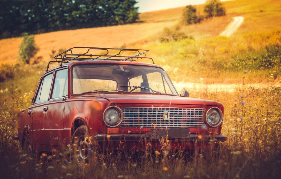 Free Image of Old Red Car Parked in Field of Tall Grass 
