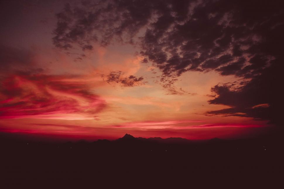 Free Image of Red Sky With Clouds and Mountain in Background 