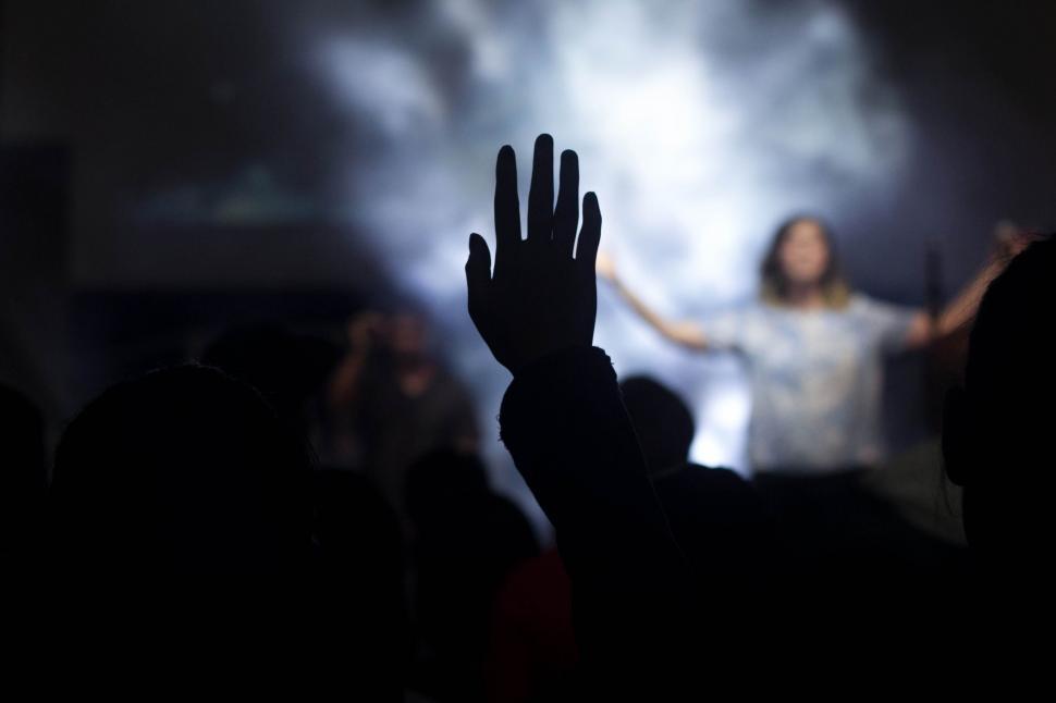 Free Image of Person Standing in Front of Stage With Hands Up 