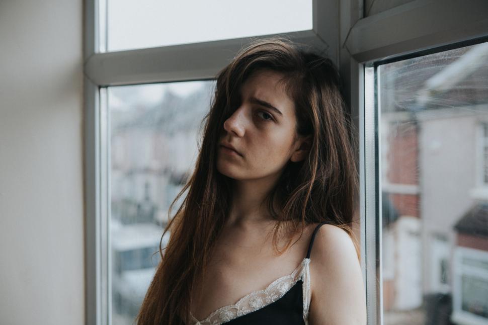 Free Image of Woman Standing in Front of Window 