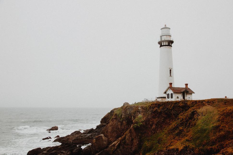Free Image of Lighthouse on Cliff Overlooking Ocean 